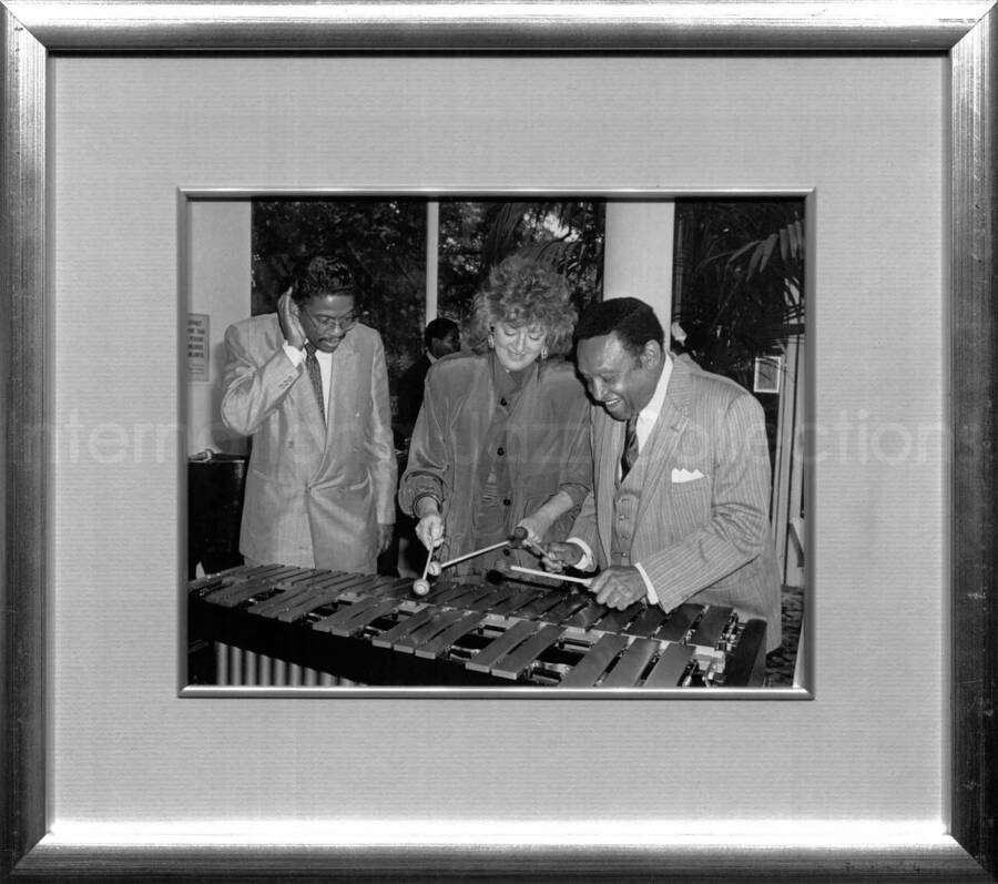13 3/4 x 15 3/4 inch frame holding a black and white photograph. Has a label on the back from the BMI Archives. Herbie Hancock, Frances W. Preston, and Lionel Hampton at the Tavern on the Green, New York
