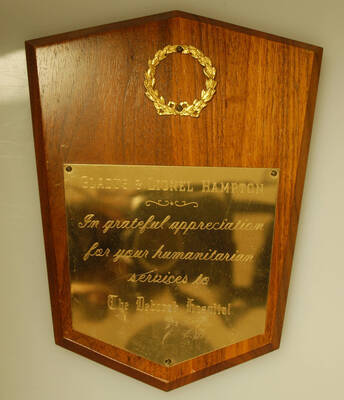 Plaque. 10"x8" Shield wood finish plaque with wreath and engraved plate To Gladys and Lionel Hampton in grateful appreciation for their services to the Deborah Hospital