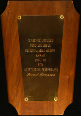 Plaque. 12"x8 3/4" Wood finish plaque with engraved plate 1969-70 Clarence Concert Wind Ensemble Distinguished Artist Award presented to Lionel Hampton for outstanding performance. [New York], 1970