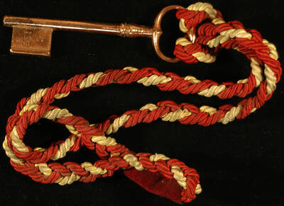Ceremonial Key. 5 3/4" Copper ceremonial key with the inscription "C 130" on one side of the tooth. It is attached by the bow to a gold and red cord