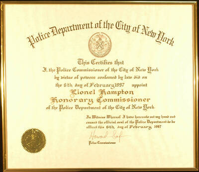 Framed Certificate. 13 1/2"x15 1/2" Gold aluminum frame holding a certificate with gold foil seal under glass Title of Honorary Commissioner presented to Lionel Hampton by the Police Department of the City of New York. Howard Safir, Police Commissioner. New York, NY, Feb. 6, 1997