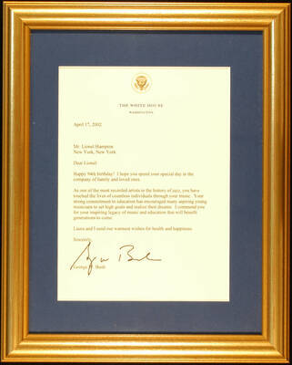 Plaque. 12 1/2"x10" Gold frame holding a letter from George W. Bush to Lionel Hampton, dated from April 17, 2002, in blue mat under glass. The letter is on paper from the White House, Washington, D.C. Letter congratulating Lionel Hampton on his 94th Birthday