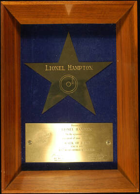 Plaque. 14"x10"x2 1/4" Wood frame holding a 7"x7" Star engraved plaque and a 3"x6 3/4" engraved plaque on blue velvet background To Lionel Hampton from the Hollywood Chamber of Commerce on the occasion of the placement of his star in the Walk of Fame. Bill Welsh, President and William F. Hertz, Chairman, Walk of Fame. Los Angeles, CA, June 14, 1982