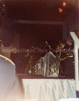 4 1/2 x 3 1/2 inch photograph. George H. W. and Barbara Bush coming on stage in front of Lionel Hampton's orchestra, on the occasion of the Inaugural Ball