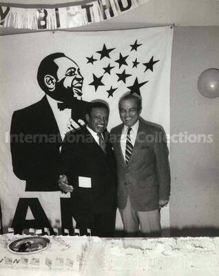 10 x 8 inch photograph. Lionel Hampton with unidentified man on the occasion of his Birthday party. A plaque on the center of the birthday cake reads: Good Will Ambassador; Lionel Hampton Vibe President