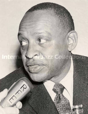 10 x 8 inch photograph. Lionel Hampton at the microphone of the Radio Free Europe. Handwritten on the back of the photograph: One of a Kind