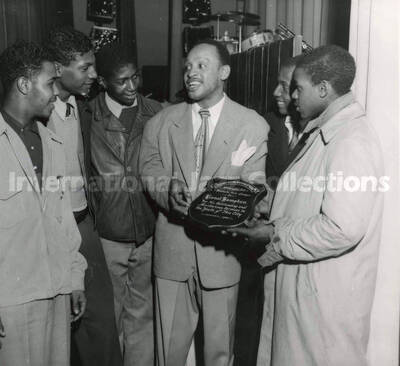 8 x 10 inch photograph. Lionel Hampton receives a plaque from the Junior Police and Citizens Corps of Washington, D.C. for his services to the youth of the city