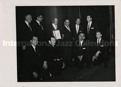 3 1/2 x 5 inch photograph. Lionel Hampton holding a plaque poses with members of the Los Angeles Chapter of Hadassah, on the occasion of his being awarded the certificate of the Hadassah Vocational Education Scholarship for his devotion to the State of Israel. Los Angeles, CA