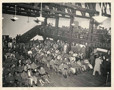 8 x 10 inch photograph. An audience primarily of men in military uniform