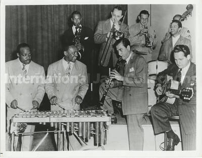 8 x 10 inch photograph. Highlights of 1944 Command Performance program on the Armed Forces Radio Service, ensemble performing: Honeysuckle Rose. Produced in Hollywood.  L to r.: Count Basie (vb), Lionel Hampton (vb), Artie Shaw (cl), Les Paul (gtr), Illinois Jacquet (tnr sax), Tommy Dorsey (tbn), Ziggy Elman (tpt), Buddy Rich (dms), and Ed McKinney, obscured by Rich (bs)