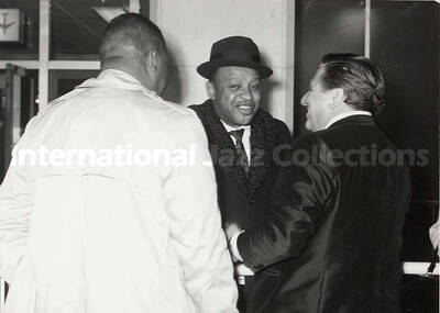 4 1/2 x 6 1/2 inch photograph. Lionel Hampton is welcomed in an airport terminal [in Japan]