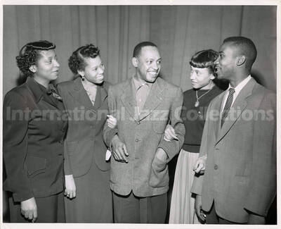 8 x 10 inch photograph. Lionel Hampton with three unidentified women and a man