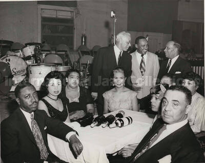 8 x 10 inch photograph. Lionel Hampton with unidentified persons. Inscribed on the drums, in background: Hamp Sonny. Handwritten on the back of the photograph: Alonorya Carter, Mildred Norman, Pitt Jerry, Barbara Jones, Simpkin 5