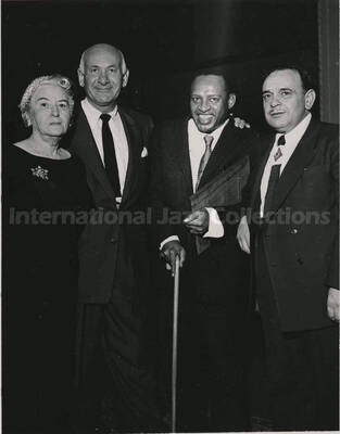 5 x 3 1/2 inch photograph. Lionel Hampton holding a plaque poses with members of the Los Angeles Chapter of Hadassah, on the occasion of his being awarded the certificate of the Hadassah Vocational Education Scholarship for his devotion to the State of Israel. Los Angeles, CA