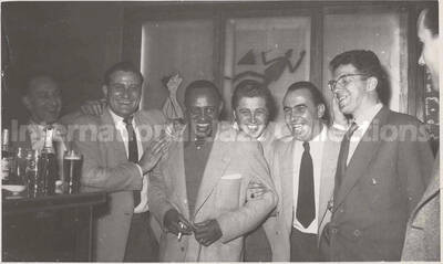 3 1/2 x 5 1/2 inch photograph in the format of postcard. Lionel Hampton with unidentified men. Handwritten on the back of the photograph: Just a little memory from the band of Frascati's Stuttgart-Germany