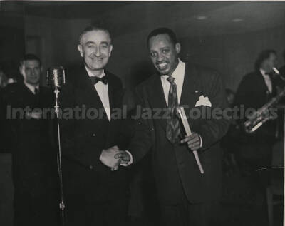 8 x 10 inch photograph. Lionel Hampton with Hirsh de La Viez. Handwritten on the back of the photograph: In background, Arnold Fine, drama editor - Wash. Daily News; Hirsh de La Viez - Pres. Washington Music Guild[?]