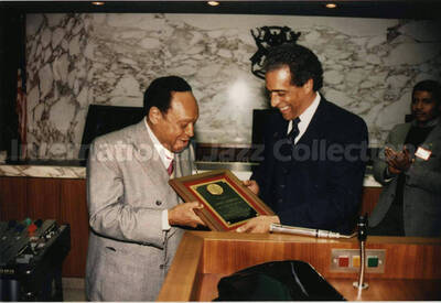 3 1/2 x 5 inch photograph. Lionel Hampton receives a plaque from an unidentified man, in Detroit, Michigan