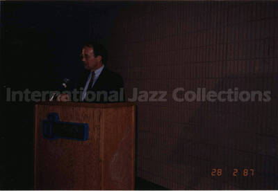 4 x 6 inch photograph. Unidentified man on podium on the occasion of the dedication of the Lionel Hampton School of Music. University of Idaho, Moscow, ID