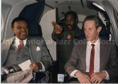 3 1/2 x 5 inch photograph. Lionel Hampton in a US Marines airplane with two unidentified men