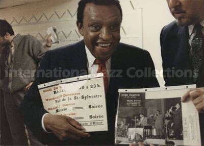 5 x 7 inch photograph. Lionel Hampton with unidentified man holding an old program from a concert at the Palais d'Hiver