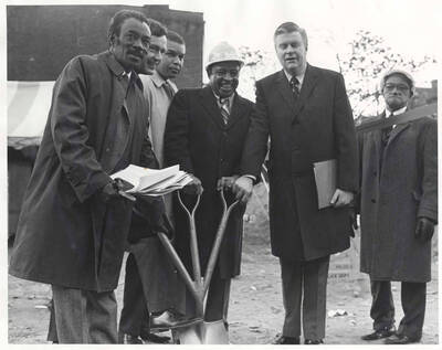 10 x 8 inch photograph. Lionel Hampton with unidentified men holding a shovel with three handles at the ground breaking ceremony of the Lionel Hampton Houses
