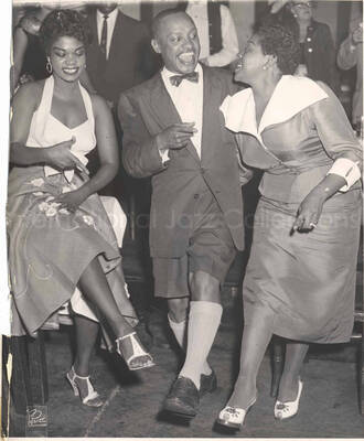 10 x 8 inch photograph. Lionel Hampton with Dinah Washington and unidentified woman, in a restaurant