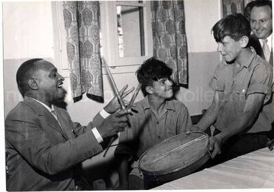 5 x 7 inch photograph. Lionel Hampton with unidentified persons visiting with children in Israel