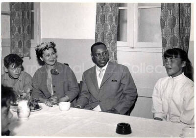 5 x 7 inch photograph. Lionel Hampton with unidentified woman visiting with children in Israel. Handwritten on the back of the photograph: L. Hampton at Swiss Village