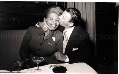 5 x 8 inch photograph. Vocalist of Lionel Hampton's band with unidentified man in a restaurant in Israel