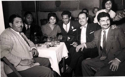 5 x 8 inch photograph. Curley Hamner with unidentified persons in a restaurant in Israel