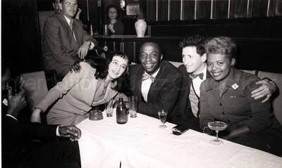 5 x 8 inch photograph. Members of the Lionel Hampton's band with unidentified persons in a restaurant in Israel