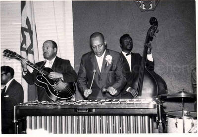4 x 5 1/2 inch photograph. Lionel Hampton on vibraphone with band, which includes guitarist Billy Mackel, at the Youth Aliyah conference, Israel