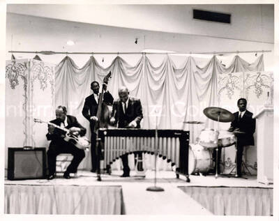 8 x 10 inch photograph. Lionel Hampton on vibraphone with two unidentified musicians and guitarist Billy Mackel