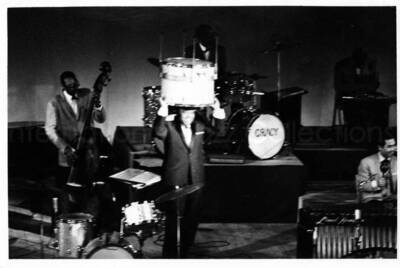 3 x 5 inch photograph. Lionel Hampton on stage with band playing in the background [in Japan?]
