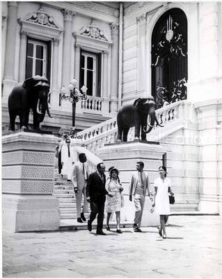10 x 8 inch photograph. Gladys and Lionel Hampton in Thailand. Typewritten note on the back of the photograph reads: Leaving the Chakri Hall of Bangkok's Grand Palace with Mrs. Hampton and members of the Jazz Inner Circle. On the right is interpreter Rudi Chakorn