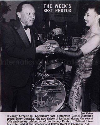 10 x8 inch photograph. This is a copy of a signed clipping from Jet Magazine entitled: The week's best photos. It depicts a photograph by Fred Watkins of Lionel Hampton greeting Terry Gonzalez, a recently-hired singer in his band, in the fifth anniversary of the Sammy Davis Jr. National Liver Institute, at the Meadowland Hilton Hotel in Secaucus, NJ