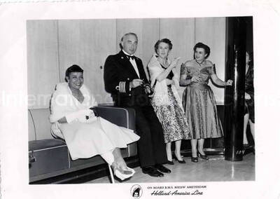4 1/4 x 5 3/4 inch photograph. Gladys Hampton with unidentified persons. Inscribed at the bottom of the photograph: on board R.M.S. Nieuw Amsterdam; Holland-America Line