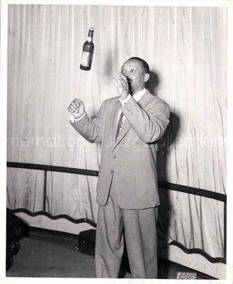 10 x 8 inch photograph. Lionel Hampton tossing a bottle of Patrick Henry beer