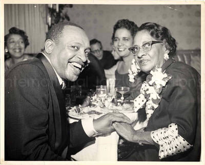 8 x 10 inch photograph. Lionel Hampton with unidentified persons in a restaurant