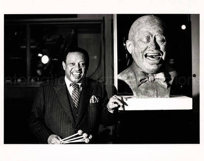 8 x 10 inch photograph. Lionel Hampton posing along his bust (sculpture)