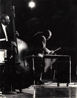 14 x 11 inch photograph. Lionel Hampton playing the vibraphone with orchestra. This photograph has a dedication from Bill Tyler