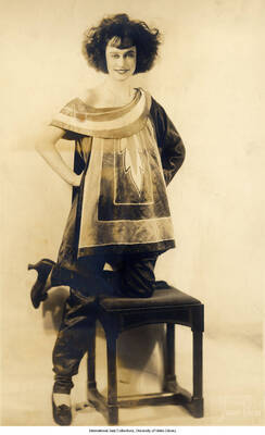 Black and white photograph of Lee Morse half-kneeling on a stool.
