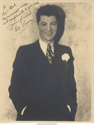 Black and white photograph of a man in a suit. Inscription: "To Lee + Bob.  My sincerest wishes and compliments to you both.  Your friend, Ed Lowry"