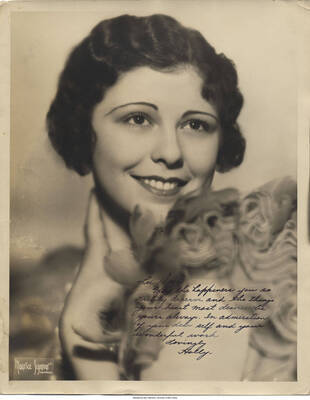 Black and white photograph of a woman. Inscription: "Lee Dear  May the happiness you so richly deserve and the things your heart most desires be yours always.  In admiration of your dear self and your wonderful work  Lovingly Holly"