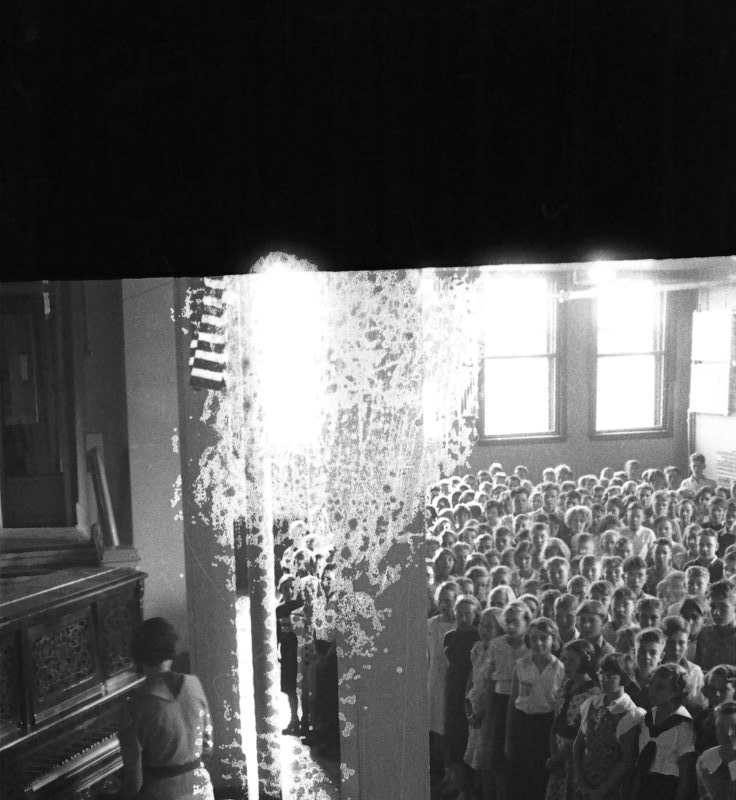 woman at piano; students crowded in a room at Whitworth School