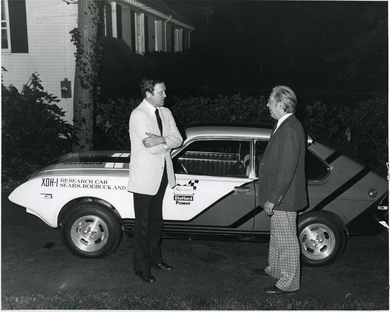 Senator James A. McClure stands with an unknown person next to a car labeled XDH-1 Research Car Sears, Roebuck and Co.