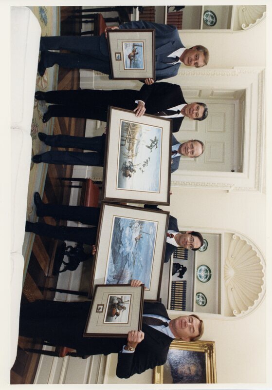 Photograph of Senator James A. McClure, President Ronald Reagan, and others holding paintings of ducks.