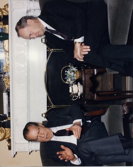 Photograph of former president Richard M. Nixon sitting next to Senator James A. McClure