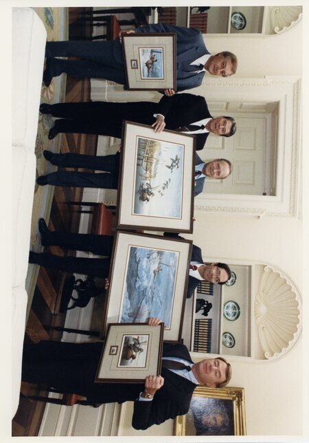 Photograph of Senator James A. McClure, President Ronald Reagan, and others holding paintings of ducks.