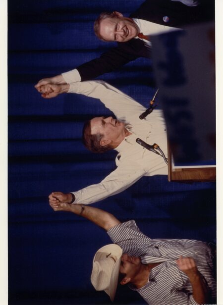 Photograph of Senator Steven D. Symms, Vice President George H. W. Bush, and Senator James A. McClure appearing onstage at a barbecue in Boise, Idaho.